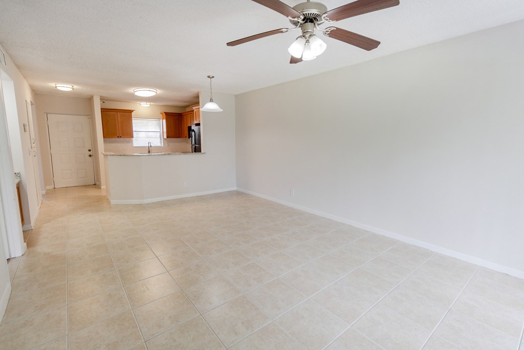A room with a ceiling fan and tiled flooring.
